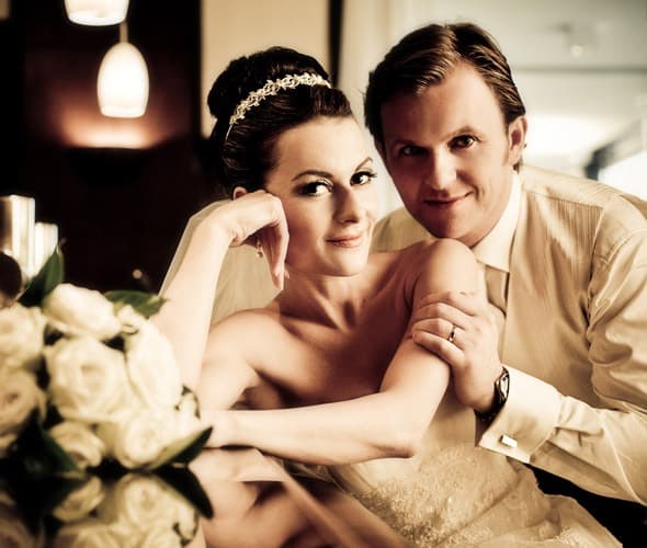 Brautpaar, die Braut mit Diadem und Hochsteckfrisur, im Vordergrund weisse Rosen