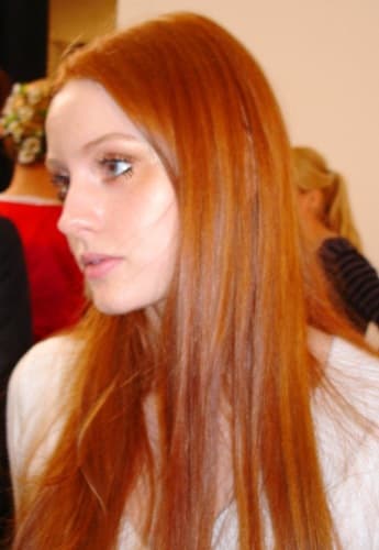Model mit langen, glatten roten Haaren im Profil